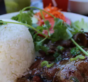 A vietnamese beef dish with rice and pickled vegetable salad at Vietnam Town restaurant.