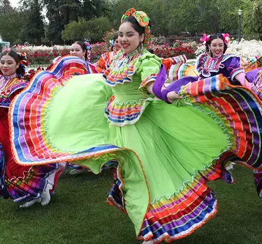 A folklorico group dancing and posing for pictures with the roses at the Municipal Rose Garden.