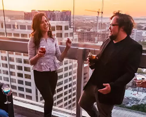 people have drinks on a balcony