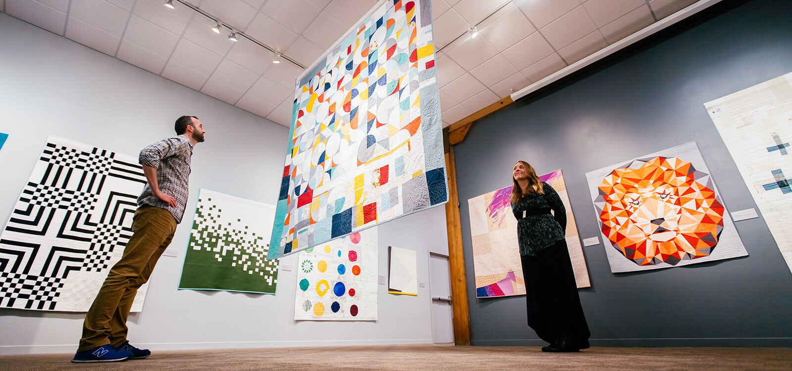 people viewing quilts