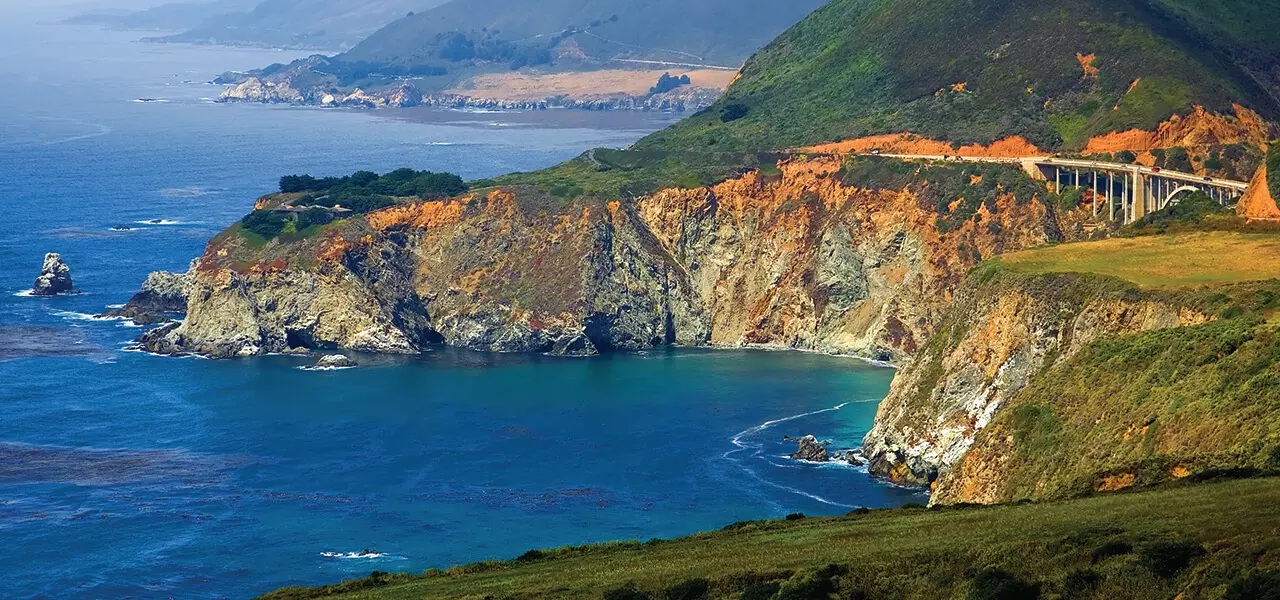 A view of the Bixby Bridge over the Pacific Ocean on a beautiful sunny day.