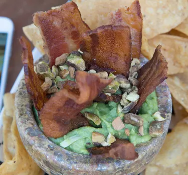 Zona Rosa's thick slices of bacon sticking out of a giant bowl of guacamole garnished with pastachios.