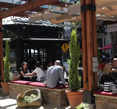 View of a full patio at Vintage Wine Bar and the unique wine bar room in the background