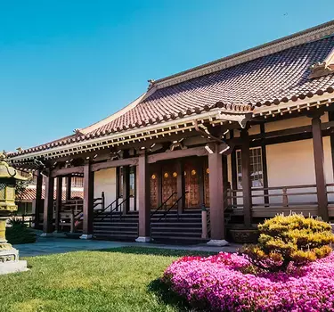 The exterior of the San Jose Buddhist Church Betsuin with bright purple flowers