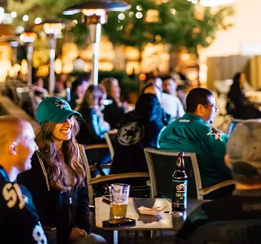 A crowd of Sharks fans have some pre-game drinks on the patio at San Pedro Square Market