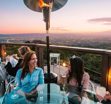 Group dining on the pation of GrandView Restaurant at dusk overlooking the city lights of Silicon Valley