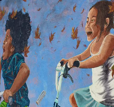 A mural of kids riding bikes on the outside of the recycle bookstore