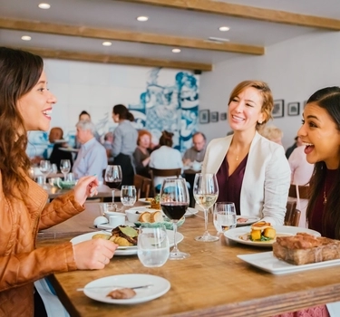 Friends dining together at ADEGA in Little Portugal in San Jose, California 