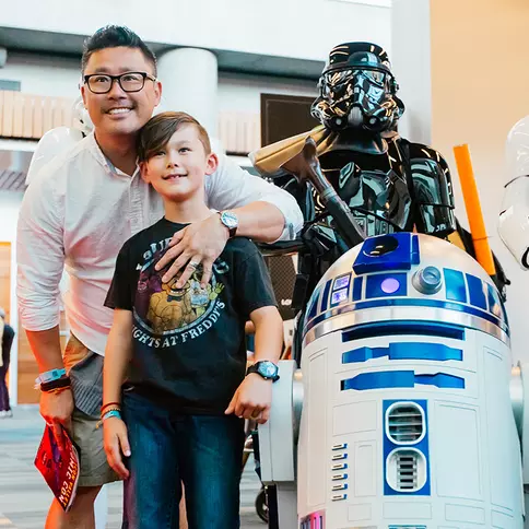 Family posing with various robots and characters.