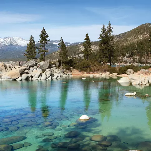 Clear blue lake surrounded by mountains.