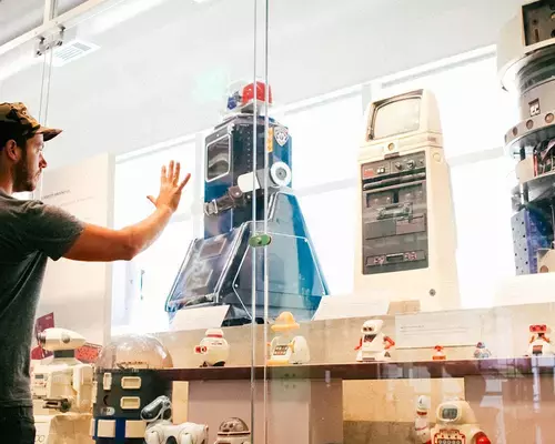 A visitor looking at a robotics exhibit inside the Computer History Museum