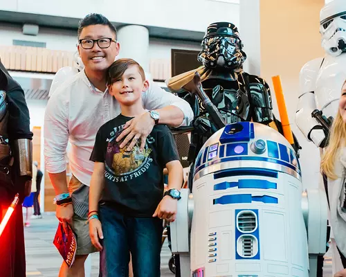 Family posing with various robots and characters.