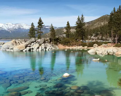 Clear blue lake surrounded by mountains.