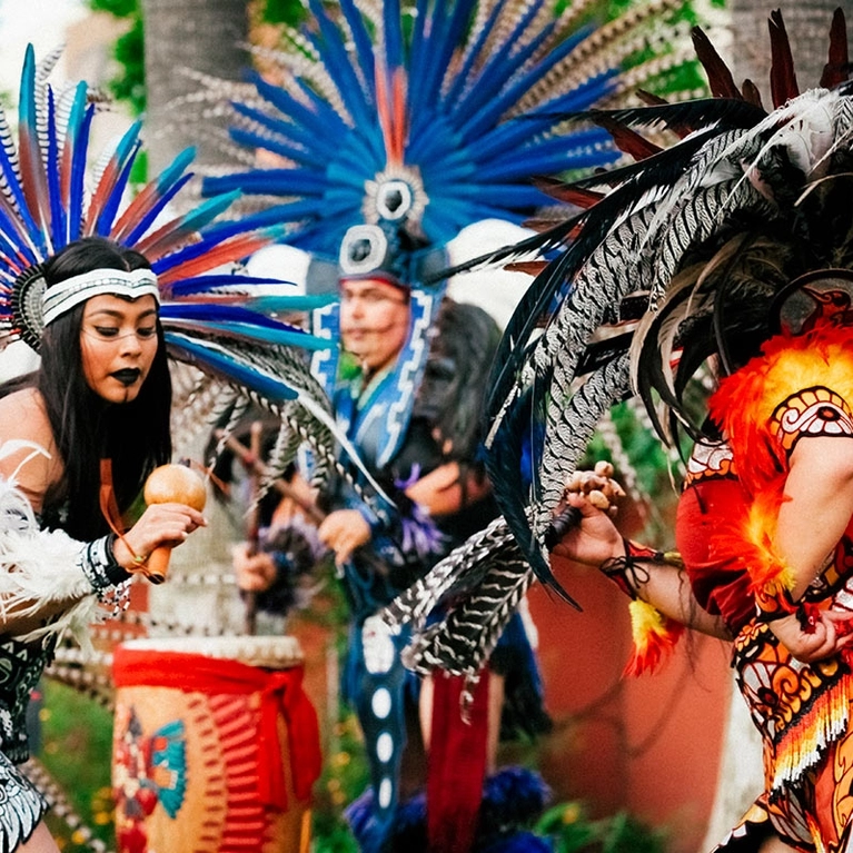 Calpulli Tonalehqueh Native American dancers in headdress and costumes playing instruments in San Jose