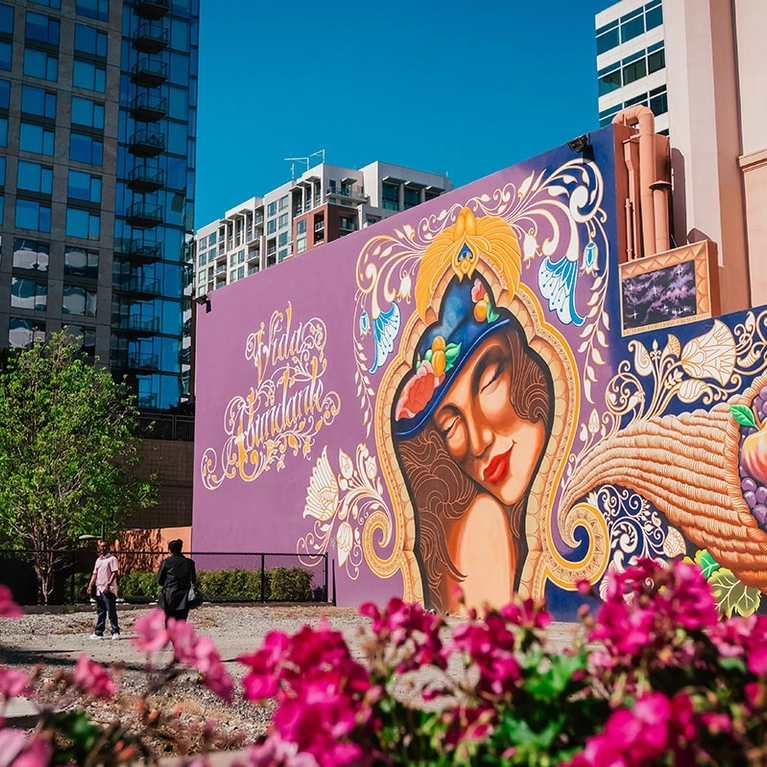 The colorful Vida Abundant mural, a woman with cornucopia, painted on the side of Hotel De Anza in Downtown San Jose