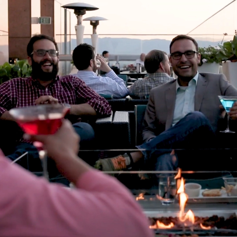 Colleagues chatting around a fire in Downtown San Jose
