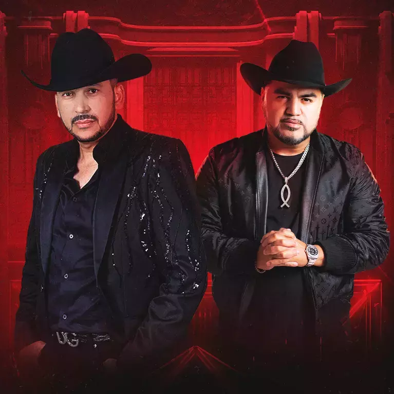 Two Latino musicians dressed in black and wearing black cowboy hats on a red background